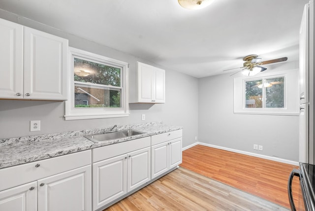 kitchen with a ceiling fan, white cabinetry, plenty of natural light, and a sink