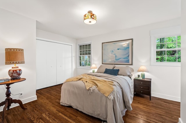 bedroom featuring wood finished floors, baseboards, and a closet