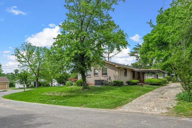 view of front of home featuring cooling unit, brick siding, a front yard, and driveway