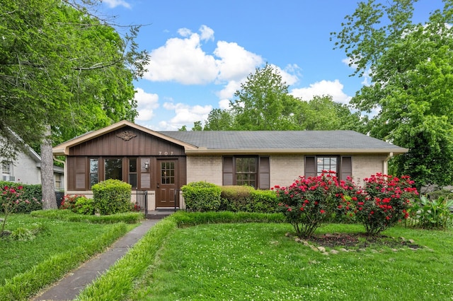 ranch-style house with a front yard, brick siding, and a shingled roof