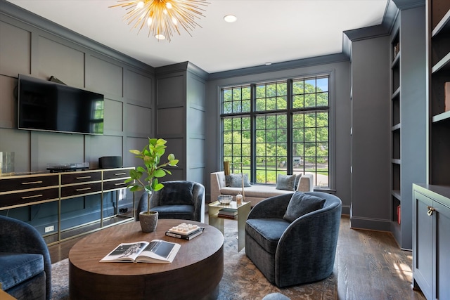living area with a decorative wall, a chandelier, dark wood-style floors, ornamental molding, and built in features