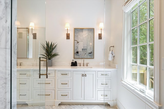 full bathroom featuring double vanity, a shower, and marble finish floors