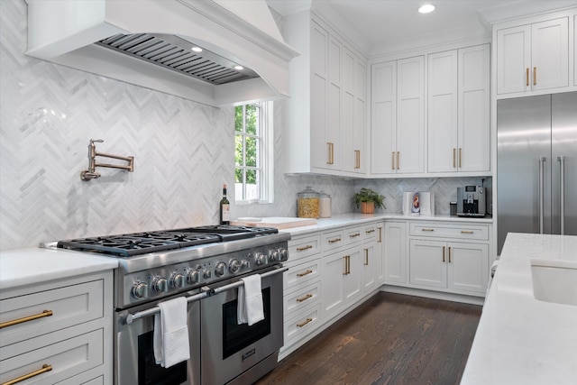 kitchen featuring high quality appliances, light countertops, custom exhaust hood, white cabinets, and tasteful backsplash