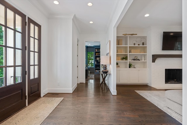 entryway with crown molding, dark wood-style floors, a fireplace, baseboards, and recessed lighting