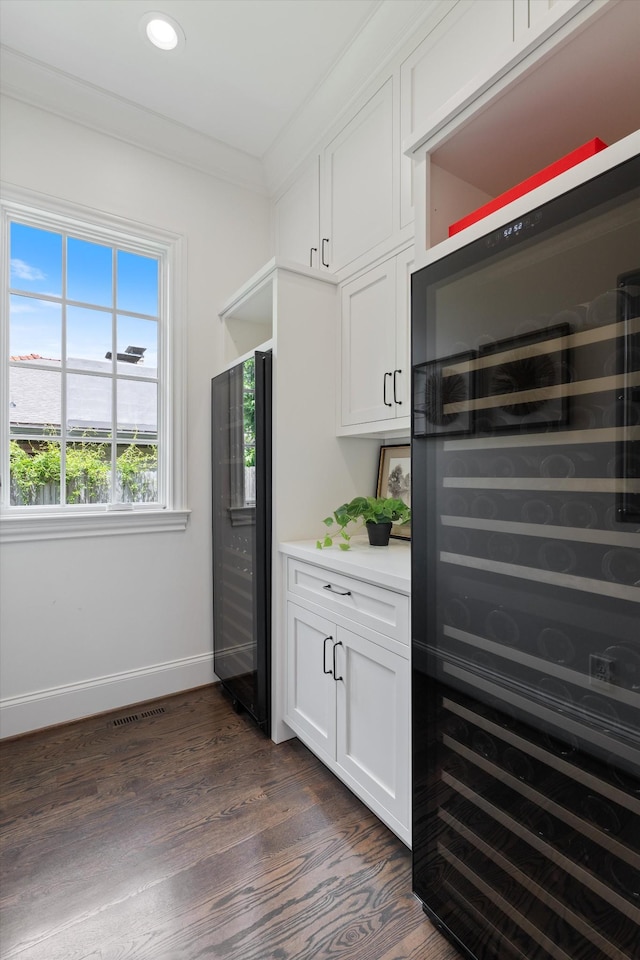 bar area with wine cooler, baseboards, dark wood finished floors, recessed lighting, and ornamental molding