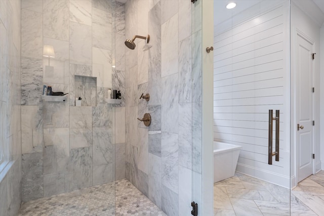 bathroom featuring marble finish flooring, a tile shower, a freestanding bath, and recessed lighting