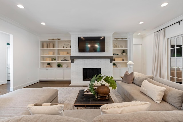living area featuring crown molding, wood finished floors, baseboards, recessed lighting, and built in features