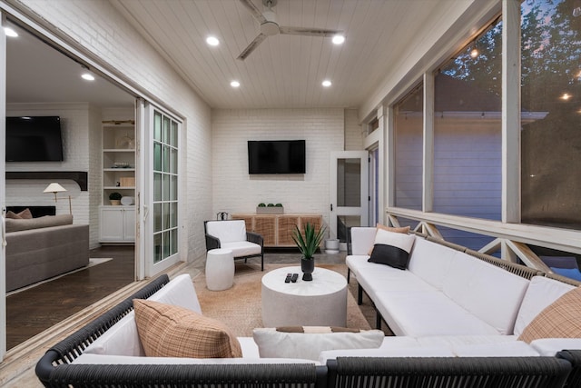 sunroom / solarium featuring an outdoor living space with a fireplace and a ceiling fan