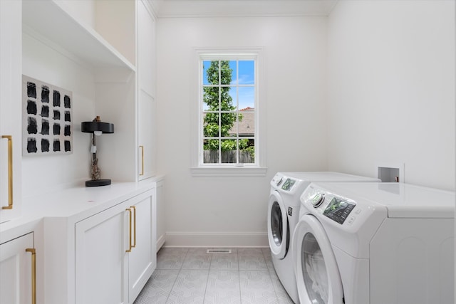 laundry room with washer and clothes dryer, cabinet space, and baseboards