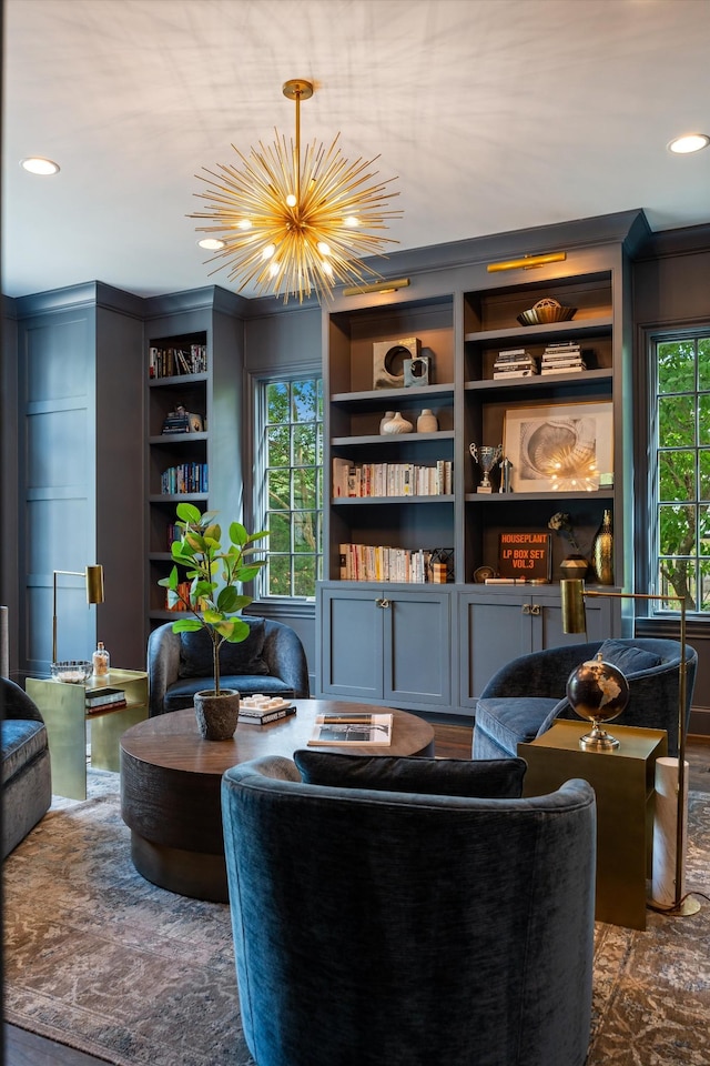 living area with a chandelier, built in features, recessed lighting, and ornamental molding