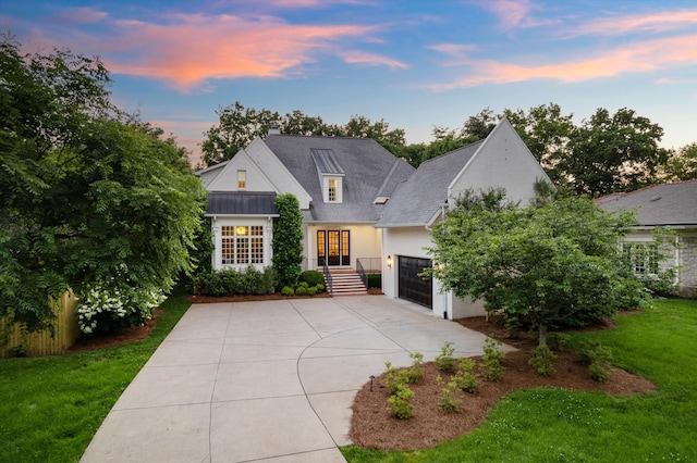 view of front of property featuring concrete driveway, an attached garage, stucco siding, a chimney, and a lawn