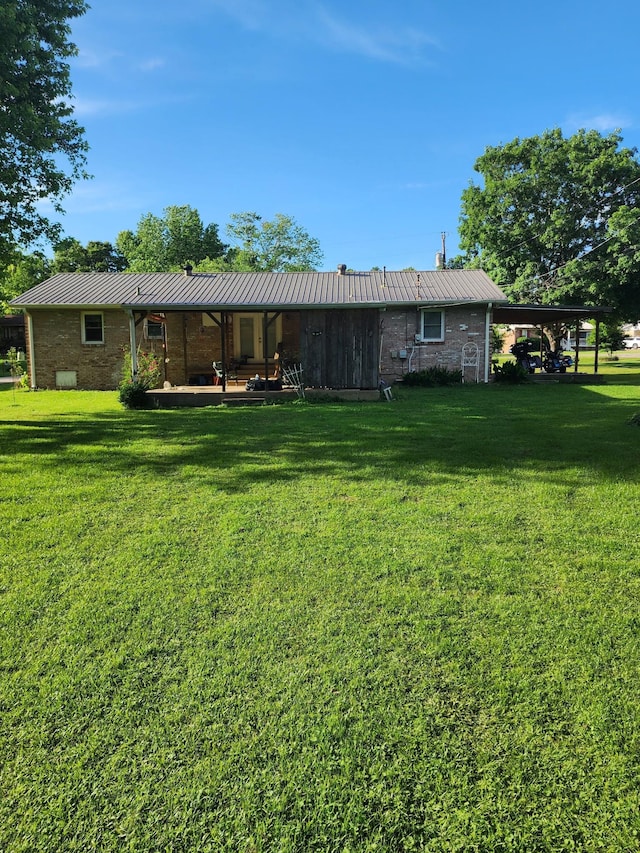 348 Leader Dr, New Johnsonville, TN 37134 - rear view of property featuring a lawn, metal roof, brick siding, a standing seam roof, and a chimney