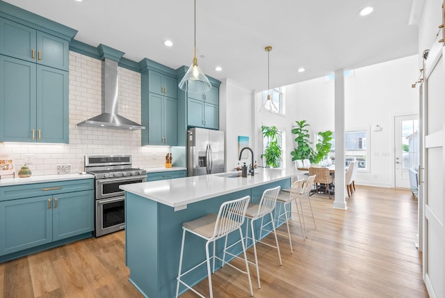 372 Augusta Ave, Pleasant View, TN 37146 - kitchen featuring stainless steel appliances, a sink, wall chimney range hood, a kitchen breakfast bar, and tasteful backsplash