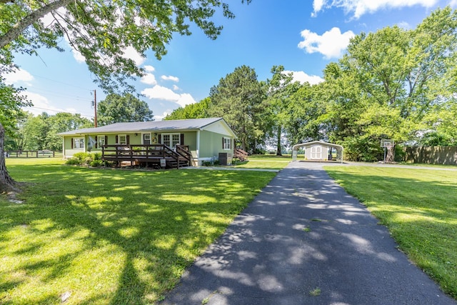 7547 Elm Springs Rd, Orlinda, TN 37141 - ranch-style home featuring a detached carport, a wooden deck, driveway, an outdoor structure, and a metal roof