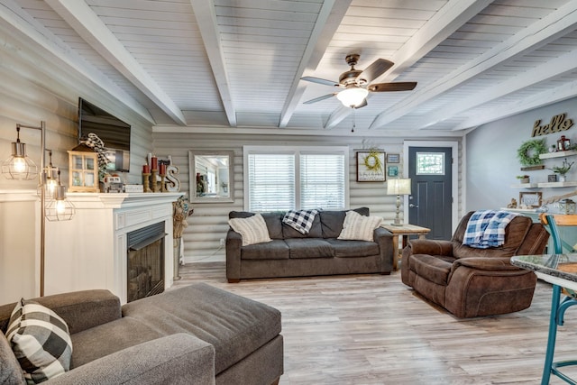 7547 Elm Springs Rd, Orlinda, TN 37141 - living room with a fireplace, light wood-style flooring, beam ceiling, a ceiling fan, and rustic walls