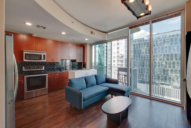 kitchen featuring stainless steel appliances, dark wood-style floors, plenty of natural light, floor to ceiling windows, and recessed lighting