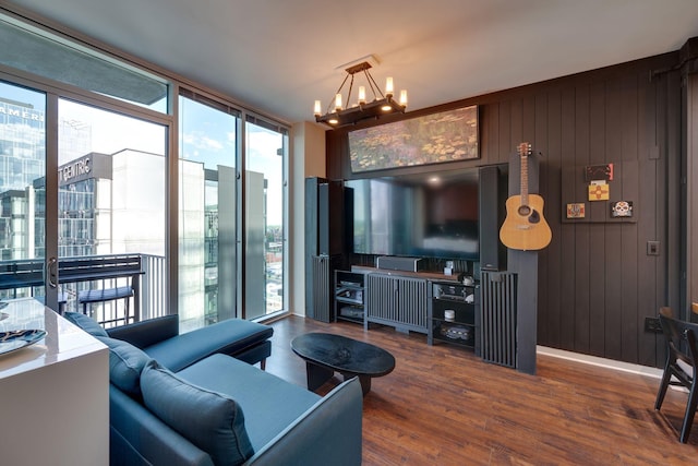 living area with a chandelier, wood finished floors, expansive windows, and wooden walls