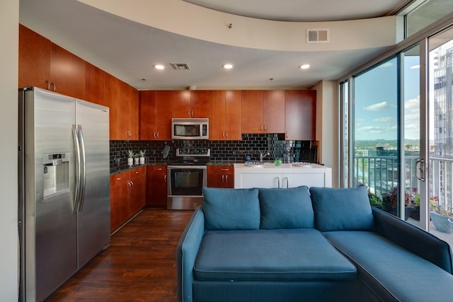 kitchen featuring appliances with stainless steel finishes, dark wood-style floors, open floor plan, backsplash, and recessed lighting