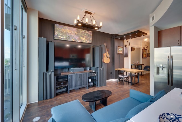 living area featuring a chandelier, wood finished floors, and baseboards