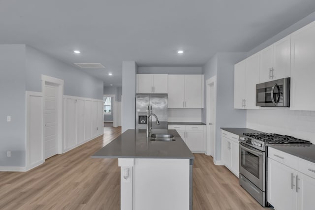 118 Merion Way, Lebanon, TN 37087 - kitchen featuring stainless steel appliances, a sink, dark countertops, light wood-style floors, and a center island with sink