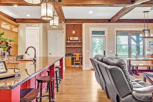 1165 River Bluffs Dr Unit Rb-97, Jasper, TN 37347 - kitchen with beam ceiling, light wood-style floors, a kitchen bar, a sink, and stone countertops