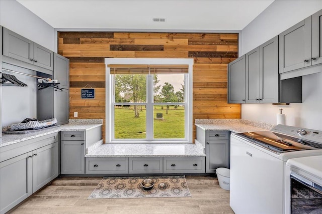 1165 River Bluffs Dr Unit Rb-97, Jasper, TN 37347 - clothes washing area with cabinet space, washing machine and dryer, wooden walls, and light wood-style floors