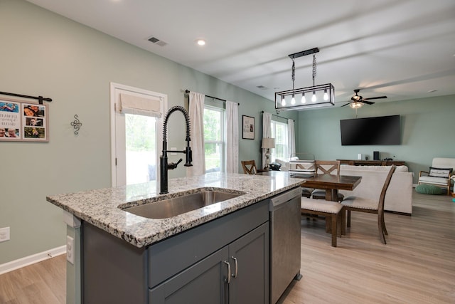 1017 Village Ct, Burns, TN 37029 - kitchen featuring a sink, dishwasher, gray cabinetry, light wood-style floors, and an island with sink