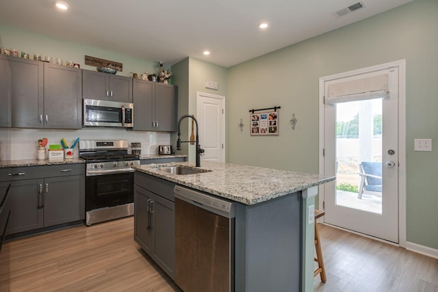 1017 Village Ct, Burns, TN 37029 - kitchen with appliances with stainless steel finishes, a sink, light wood-type flooring, light stone counters, and recessed lighting