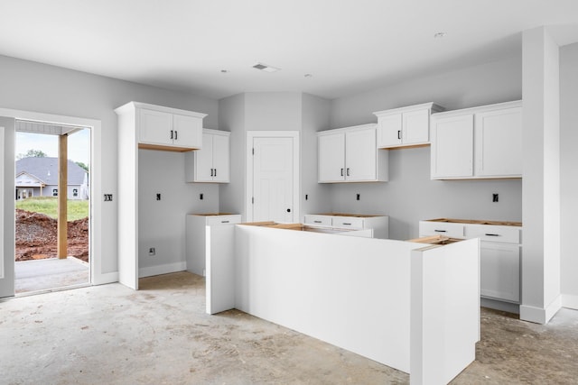 961 Isaac Dr, Clarksville, TN 37040 - kitchen featuring a center island, unfinished concrete floors, white cabinetry, and baseboards