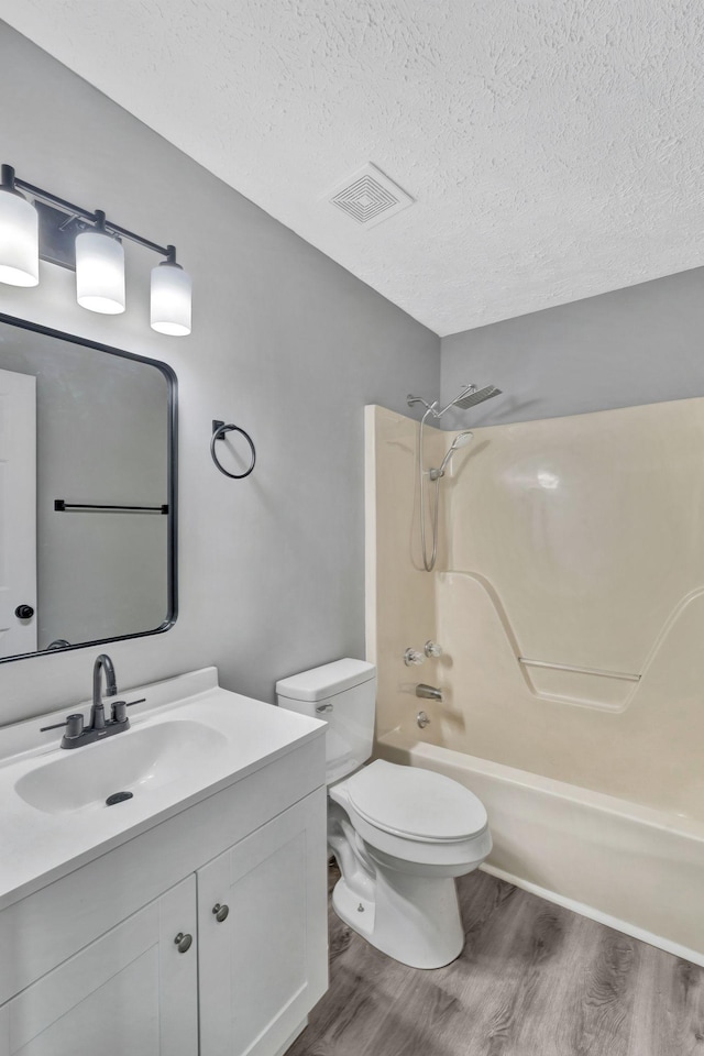 6109 Ebenezer Rd, Greenbrier, TN 37073 - bathroom featuring wood finished floors, vanity, shower / bathtub combination, a textured ceiling, and toilet