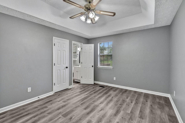 6109 Ebenezer Rd, Greenbrier, TN 37073 - unfurnished bedroom featuring baseboards, wood finished floors, a tray ceiling, and ceiling fan