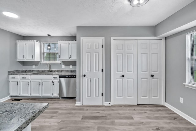 6109 Ebenezer Rd, Greenbrier, TN 37073 - kitchen with stainless steel dishwasher, a sink, white cabinetry, healthy amount of natural light, and a textured ceiling