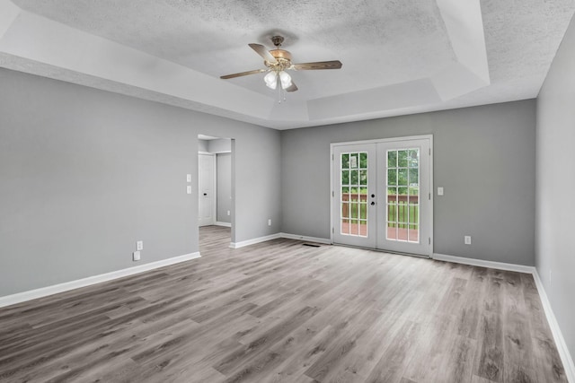 6109 Ebenezer Rd, Greenbrier, TN 37073 - spare room with a tray ceiling, a ceiling fan, a textured ceiling, wood finished floors, and baseboards