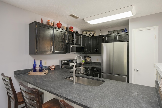 5943 Colchester Dr, Hermitage, TN 37076 - kitchen featuring stainless steel appliances, dark cabinets, dark countertops, and a sink