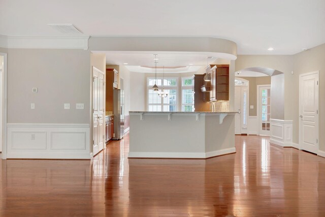 221 Antebellum Ln, Mount Juliet, TN 37122 - kitchen featuring light wood-style flooring, a breakfast bar area, arched walkways, a peninsula, and light stone counters