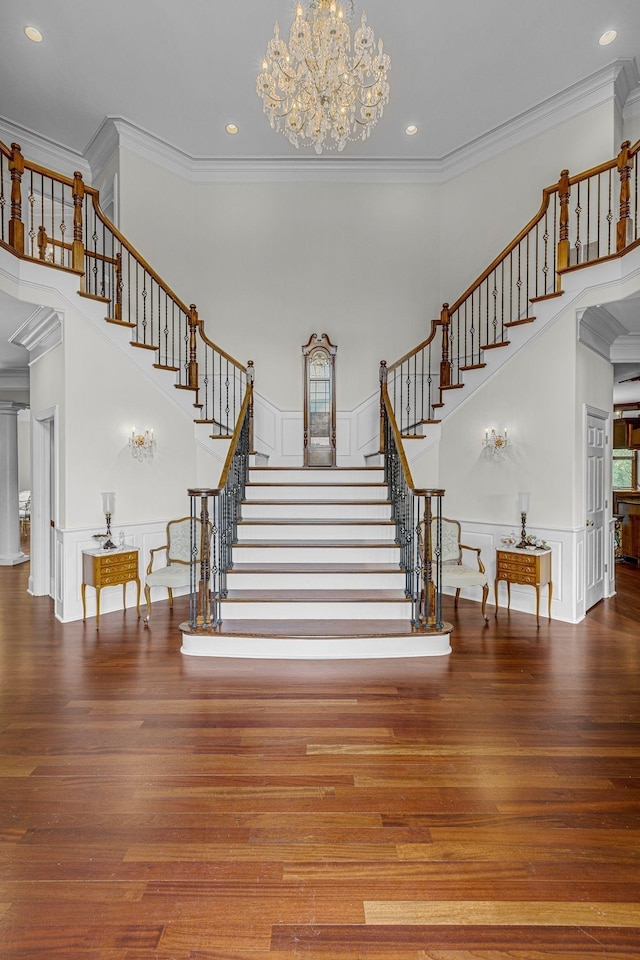 9619 Deer Track Ct, Brentwood, TN 37027 - staircase featuring wood finished floors, a towering ceiling, ornamental molding, a decorative wall, and a chandelier
