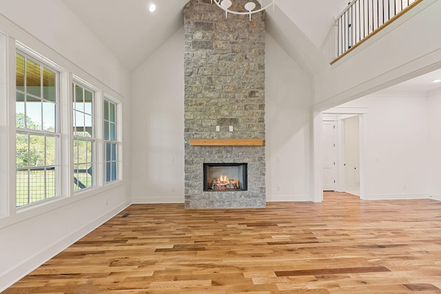 633 Post Office Rd, Rock Island, TN 38581 - unfurnished living room with light wood finished floors, high vaulted ceiling, a stone fireplace, and baseboards