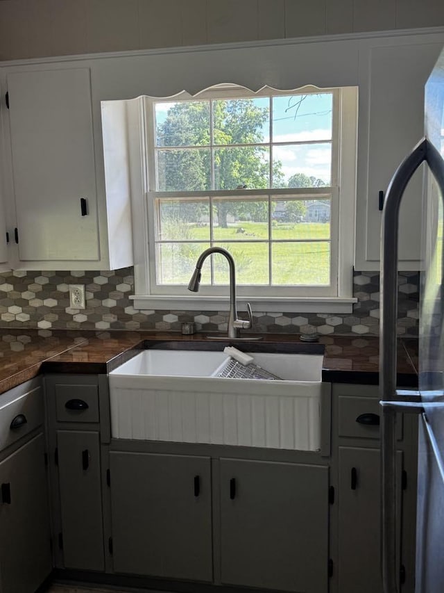 1307 Ellington Dr, Lafayette, TN 37083 - kitchen with a sink, tasteful backsplash, dark countertops, white cabinetry, and freestanding refrigerator