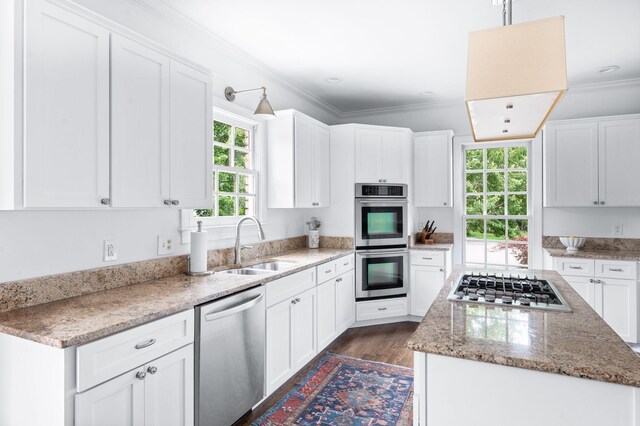 5313 Curlybark Pl, Brentwood, TN 37027 - kitchen with appliances with stainless steel finishes, a sink, a kitchen island, white cabinets, and crown molding