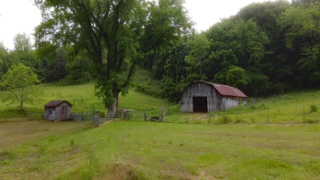 9073 Sherwood Rd, Sherwood, TN 37376 - view of yard featuring an outbuilding, a storage unit, a garage, a view of trees, and a barn