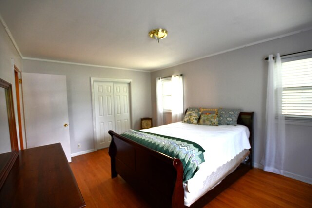 9073 Sherwood Rd, Sherwood, TN 37376 - bedroom featuring wood finished floors, multiple windows, a closet, ornamental molding, and baseboards
