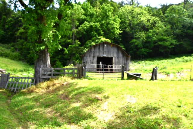 9073 Sherwood Rd, Sherwood, TN 37376 - view of yard with fence, a barn, an outdoor structure, and a view of trees