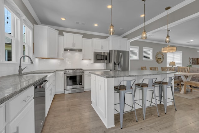 1753 Humphreys Gln, Spring Hill, TN 37174 - kitchen featuring stainless steel appliances, a sink, ornamental molding, a center island, and backsplash
