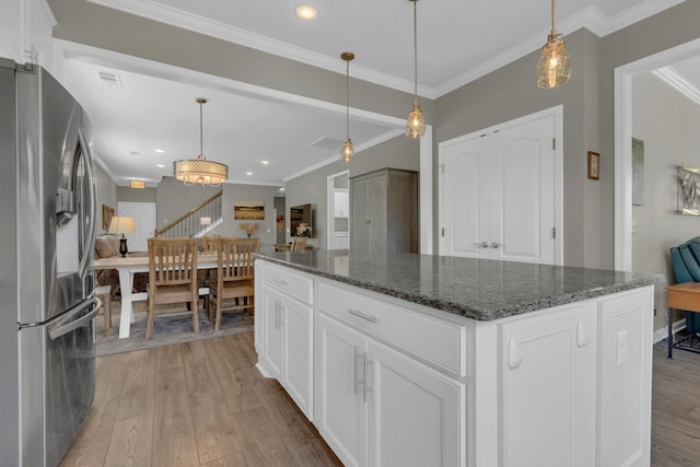 1753 Humphreys Gln, Spring Hill, TN 37174 - kitchen featuring stainless steel refrigerator with ice dispenser, light wood-type flooring, crown molding, a center island, and dark stone countertops
