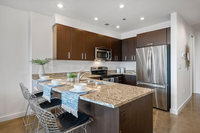 1510 Demonbreun St Unit 712, Nashville, TN 37203 - kitchen featuring appliances with stainless steel finishes, a sink, baseboards, a peninsula, and dark brown cabinets