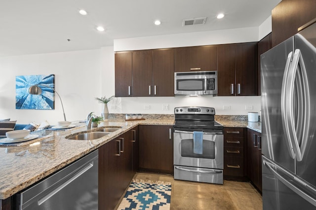 1510 Demonbreun St Unit 712, Nashville, TN 37203 - kitchen with stainless steel appliances, a sink, a peninsula, dark brown cabinetry, and recessed lighting
