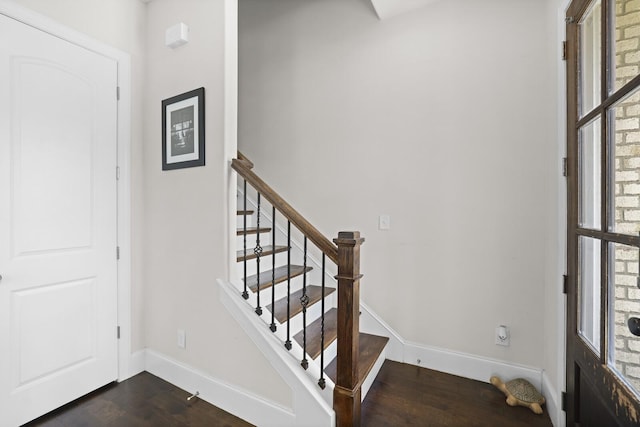 foyer with baseboards, stairway, and dark wood finished floors