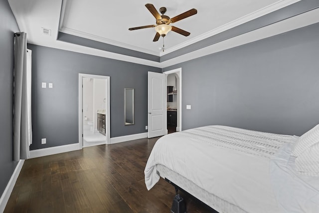 bedroom with a raised ceiling, hardwood / wood-style floors, ornamental molding, baseboards, and ensuite bathroom
