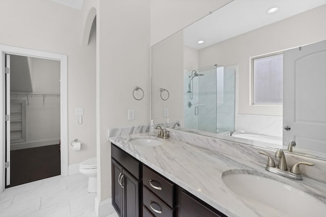 bathroom featuring a shower stall, double vanity, a walk in closet, toilet, and marble look tiles