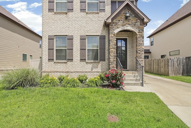 view of front of house with stone siding, entry steps, and brick siding